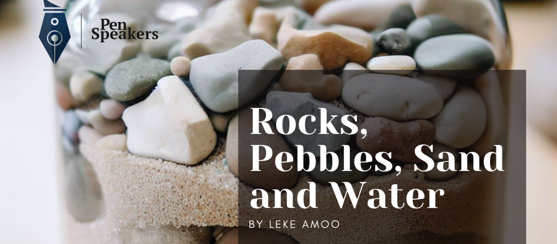 A jar containing rocks, pebbles, sand and water